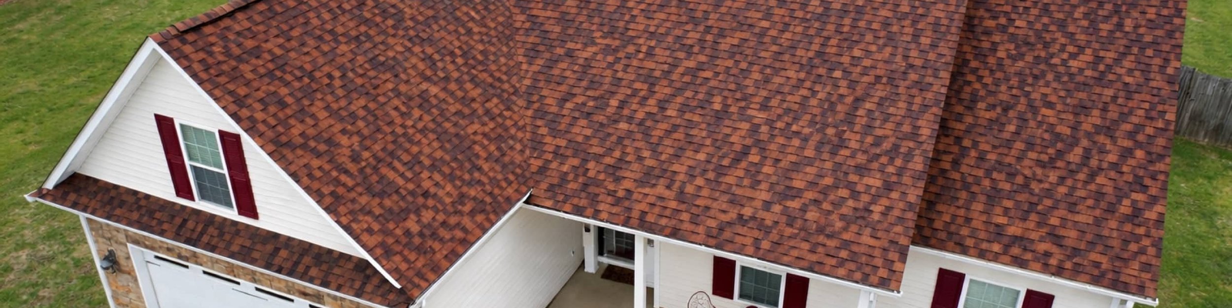 New burgundy architectural shingle roof on a white brick home in Madison, MS, seen from above