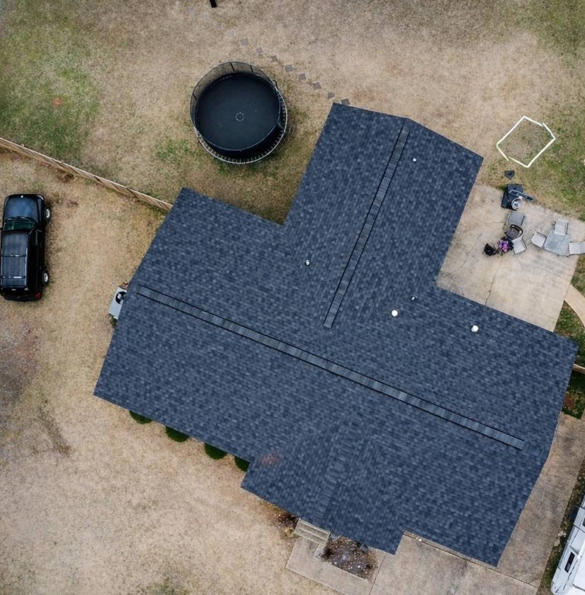 Top-down drone view of a completed black shingle roof and backyard in Madison, MS