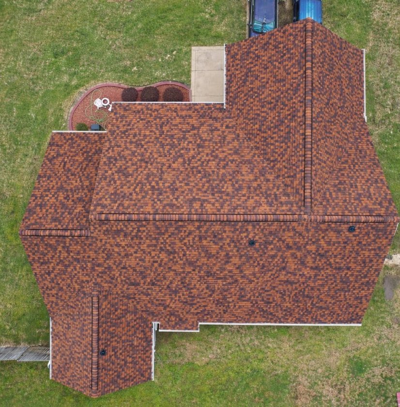 Top-down drone view of a new burgundy shingle roof on a large Madison, MS home